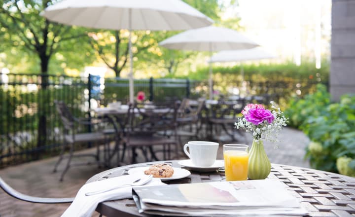 WestboroPark-home-outdoor_patio_area_with_table_in_the_foreground_with_orange_juice_and_a_newspaper_and_pastry_on_the_table WestboroPark-home-outdoor_patio_area_with_table_in_the_foreground_with_orange_juice_and_a_newspaper_and_pastry_on_the_table