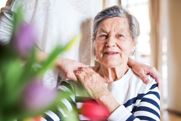 Elderly woman stock image being cared for Stock image of elderly woman being held by caregiver